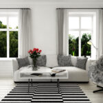 Minimalistische Couch im Wohnzimmer mit Stuhl und Decke und stilvollem Teppich