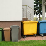 Mülltonnen unterschiedlicher Größe stehen auf der Straße.