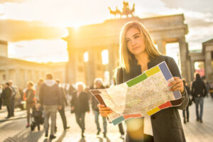 Porträt einer jungen Frau mit Landkarte in der Nähe des Brandenburger Tors in Berlin, Deutschland.
