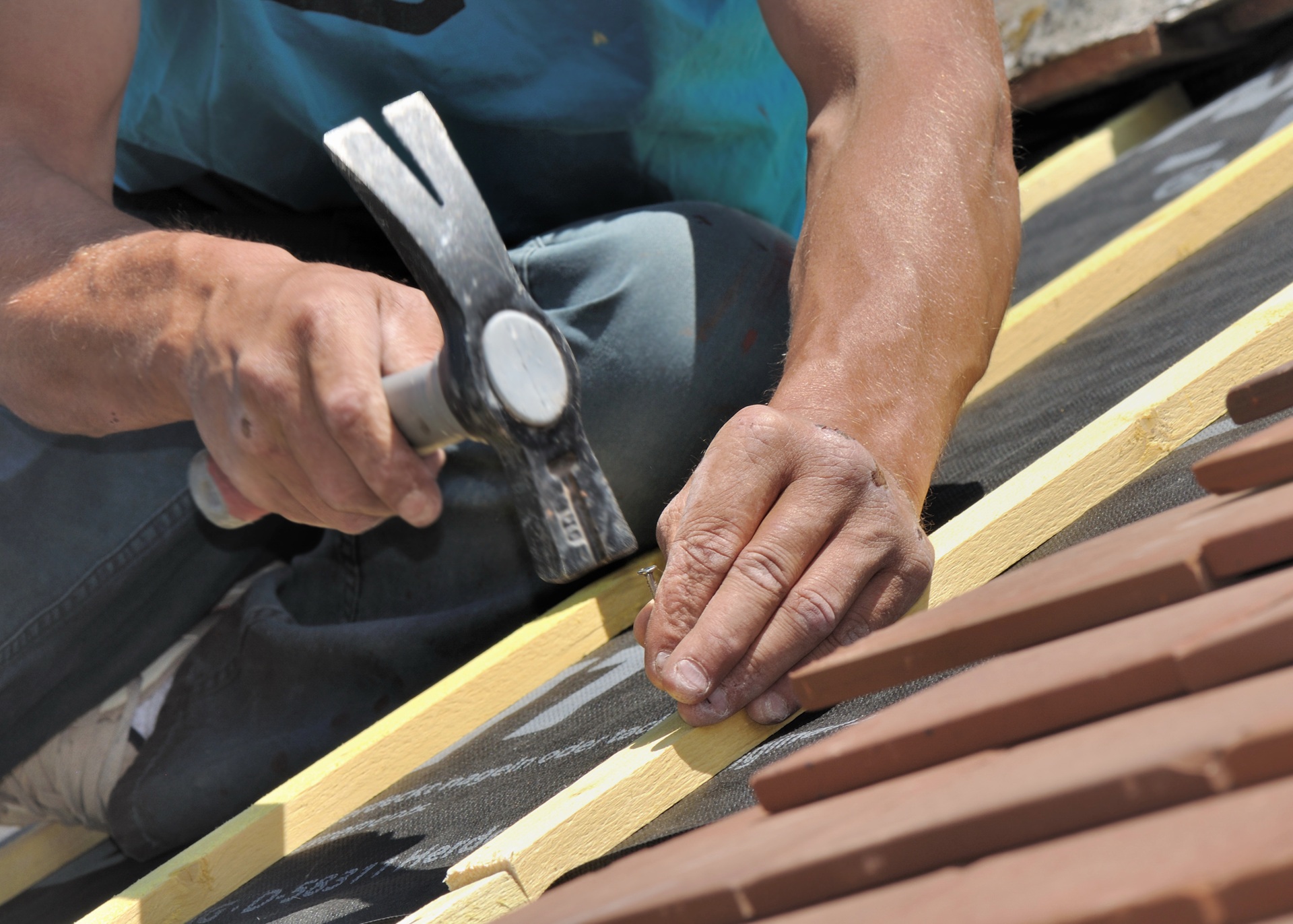 Handwerker befestigt Dachlatten bei der Dachsanierung | Arbeitsbühne mieten Bocholt